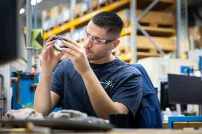 John Crane technician inspecting a mechanical seal in a workshop.