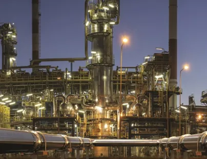 A large oil refinery at night with pipes