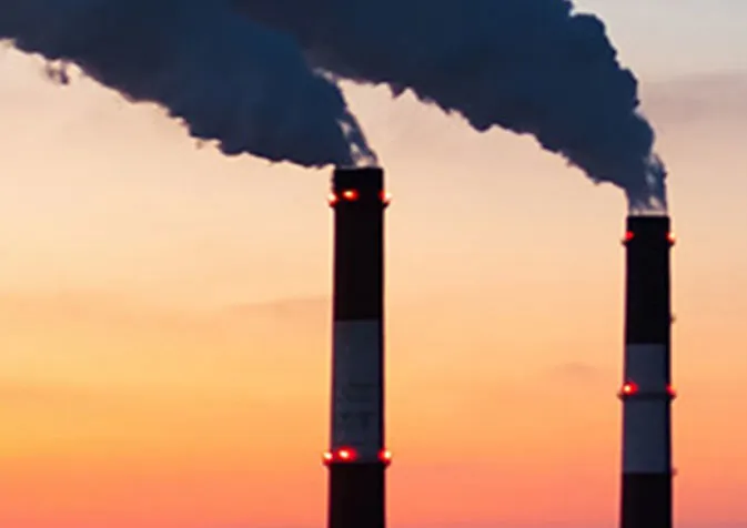 Two chimneys with smoke coming out of them