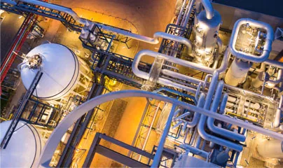 An industrial plant at night with pipes and valves