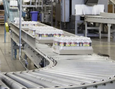 A conveyor belt with bottles on it in a factory