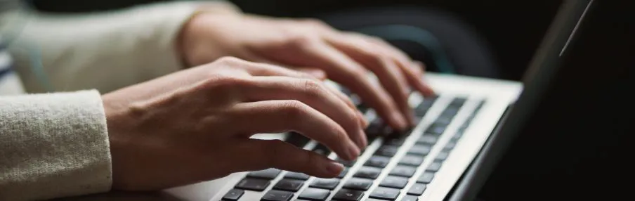 A person typing on a laptop computer