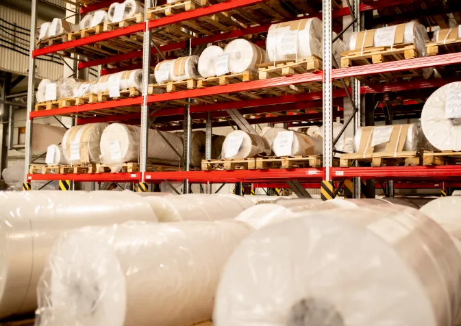 A warehouse with rolls of paper on shelves