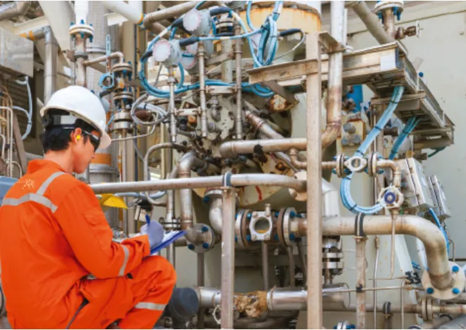 A man in an orange uniform is working on a pipe (1)