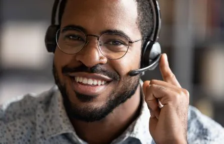 A smiling man wearing a headset