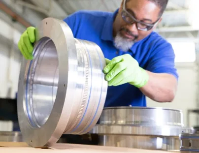 A man in a blue shirt is working on a large metal object