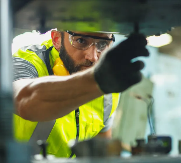 A man in safety vest working on a machine