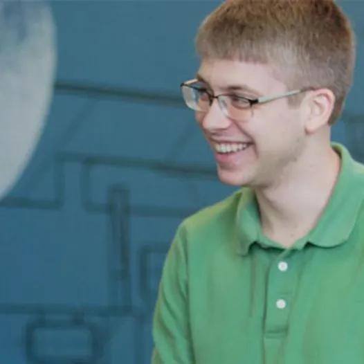 A man in a green shirt is smiling