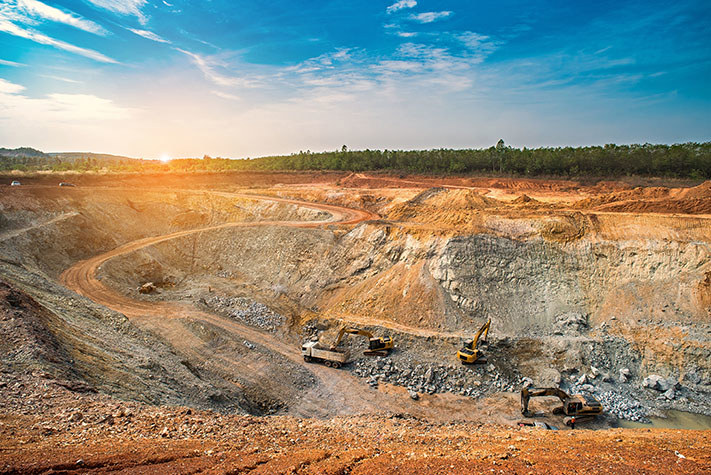 Aerial view of the open-pit mining quarry with lots of machinery at work - view from above.