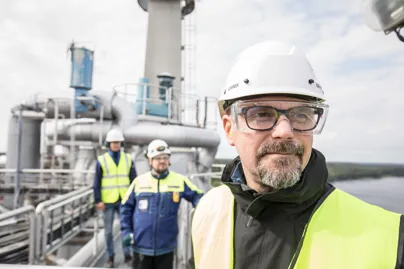 A man wearing a hard hat and safety vest standing on a platform