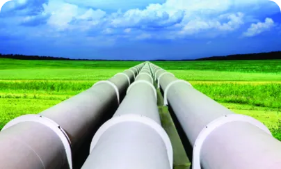 Pipelines in a field with blue sky and clouds